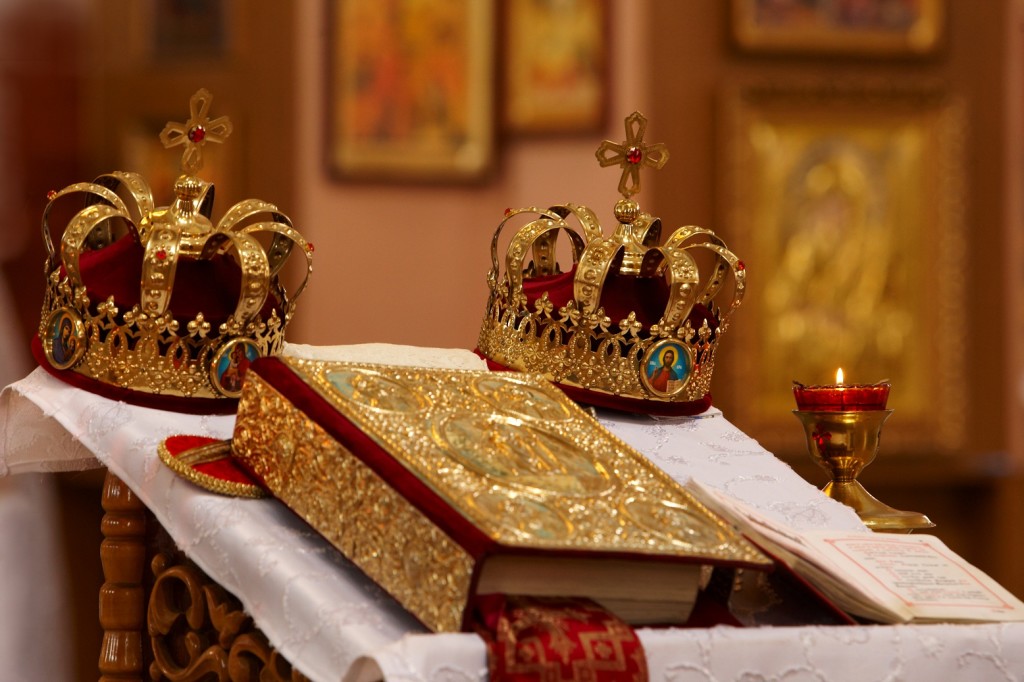 weddings crowns stand on a table near a gospel in an orthodox church